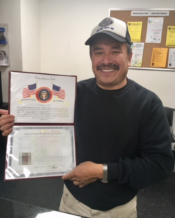 Man holding citizenship certificate.