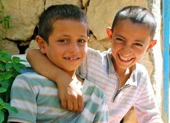 이라크 어린 소년 두 명이 미소를 지으며 사진을 찍기 위해 포즈를 취하고 있습니다.