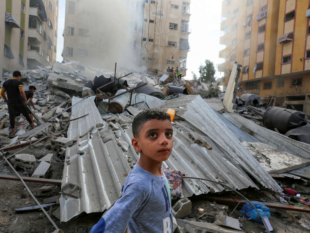 People assess the destruction cause by Israeli air strikes in Gaza City on October 7, 2023. 