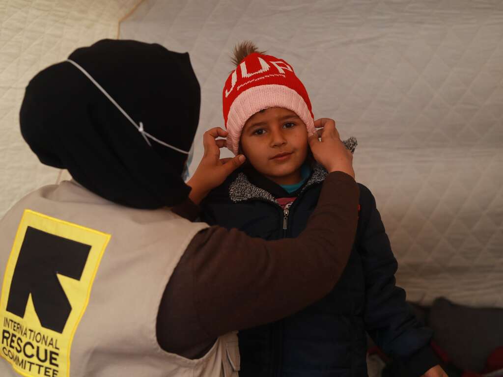 IRC worker puts hat on a boy
