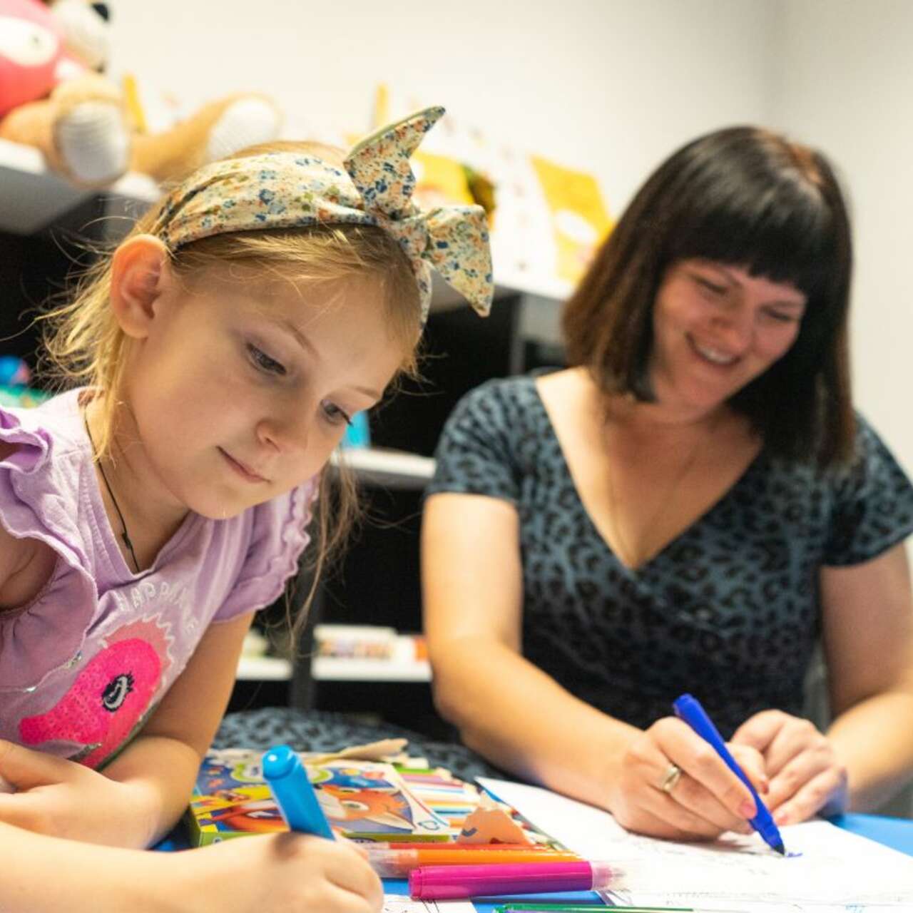 Ein kleines Kind und eine Frau malen zusammen.