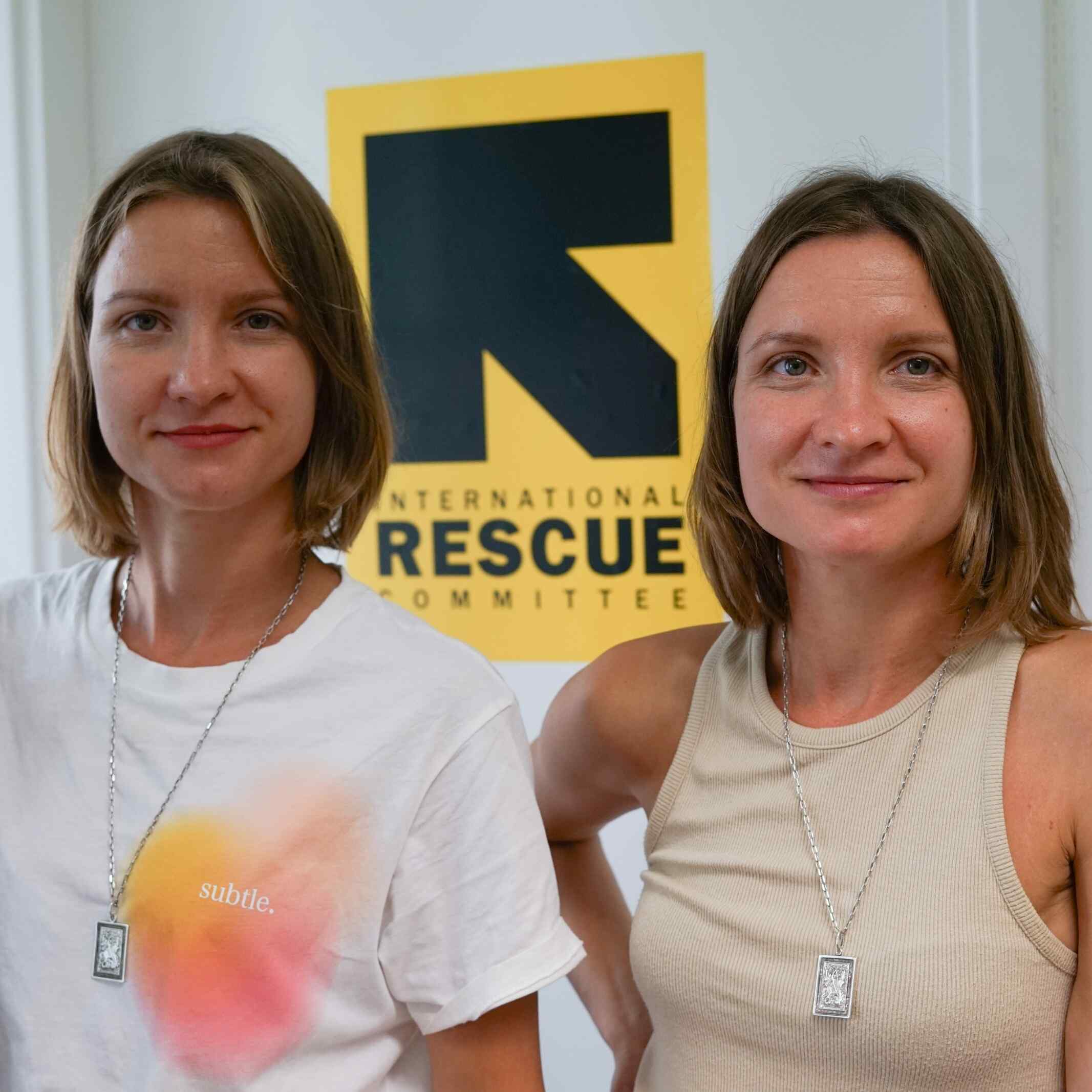 Ukrainian twins Maryana and Ruslana standing in front of the IRC logo