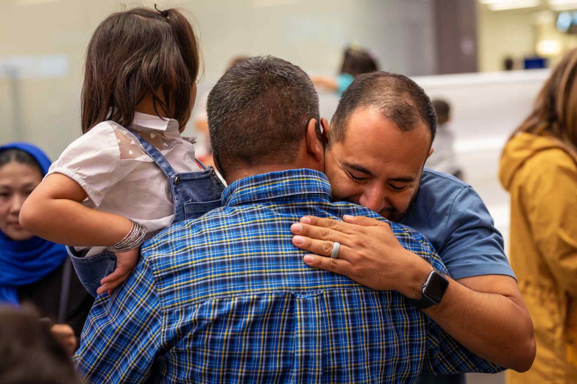 Pedro Moncada, an IRC immigration legal representative, embraces Mr. Husseini after his family was reunited.