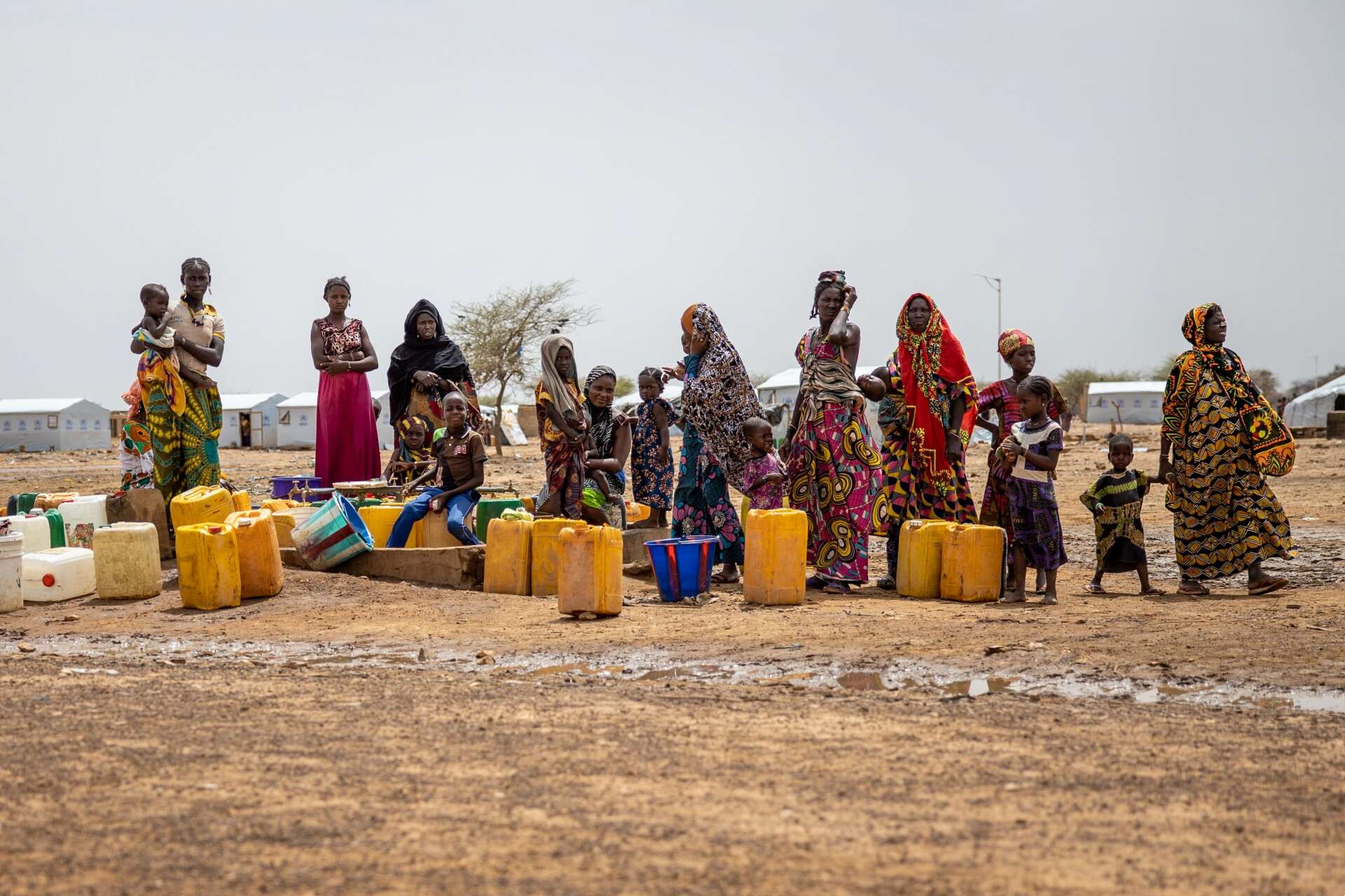 A group of women and children stand near a water collection point in Burkina Faso