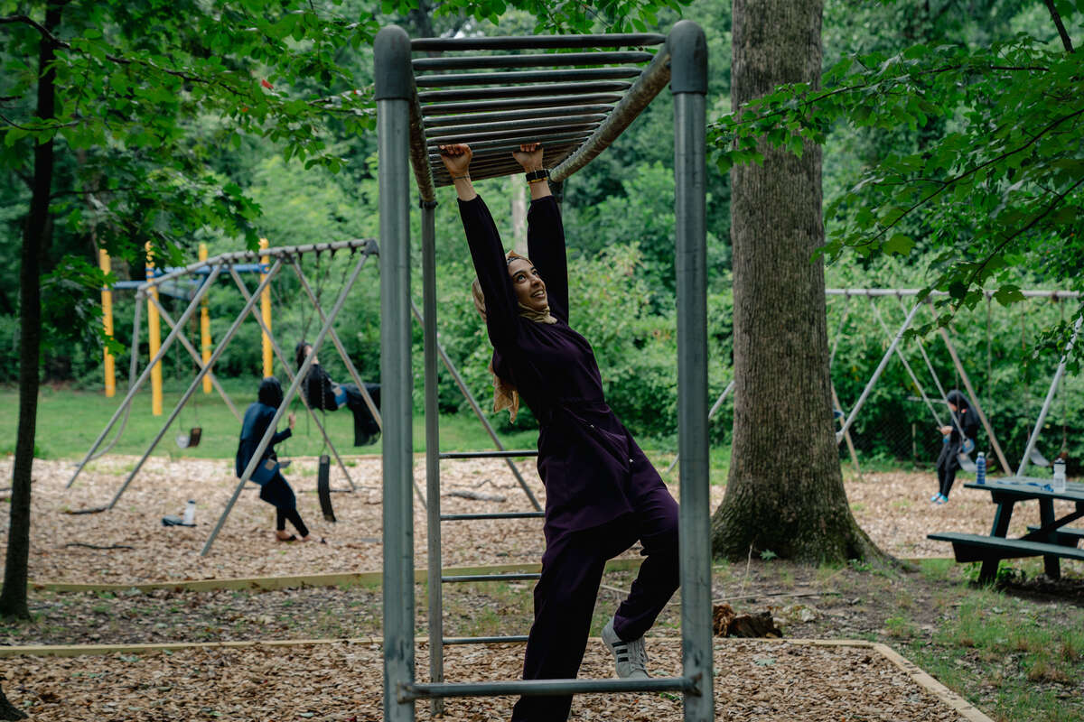 Samira climbs through parallel bars during a break at the IRC’s Summer Academy in Silver Spring, MD.