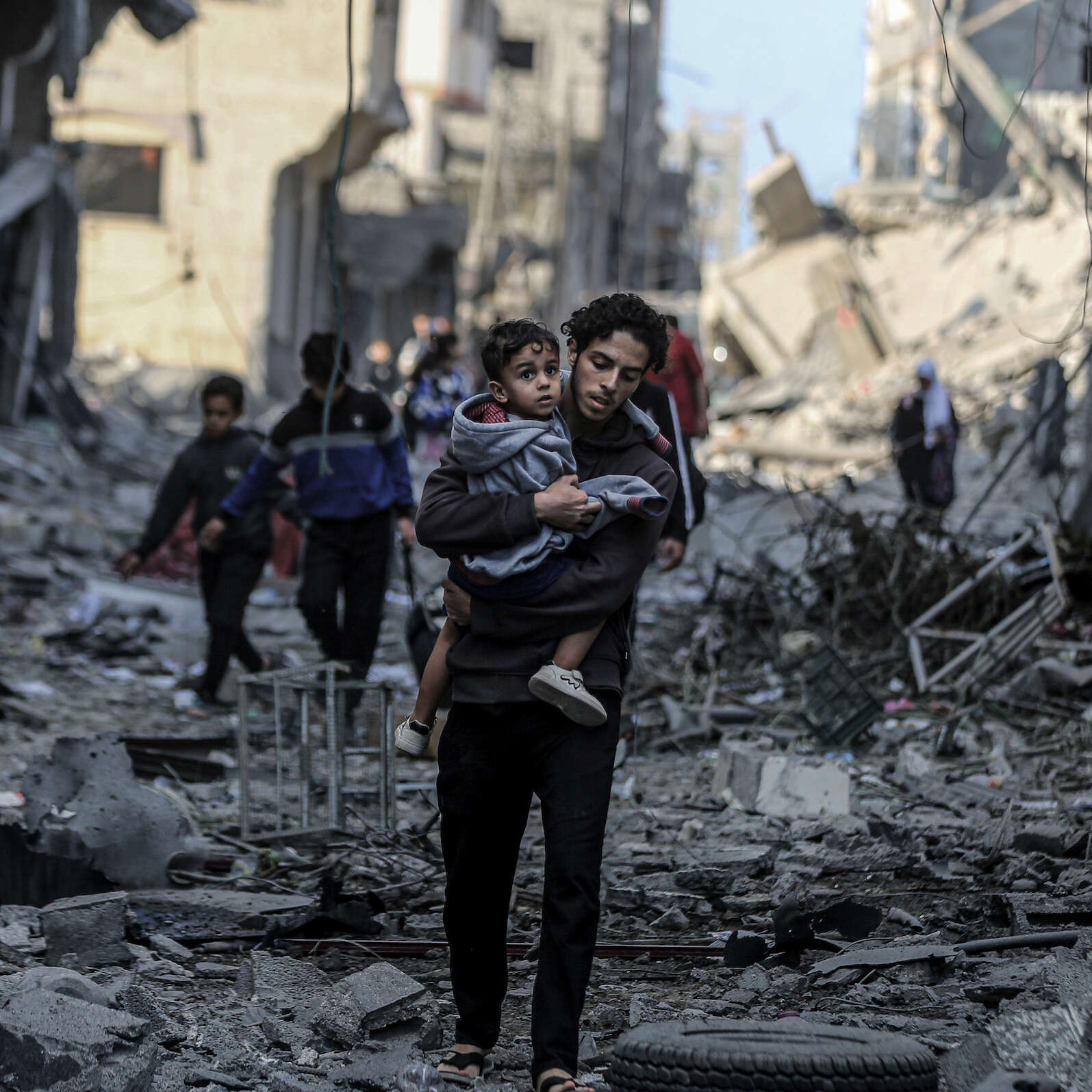 Palestinians in Gaza walk through the rubble, trying to find safety during the conflict between Israel and Hamas.
