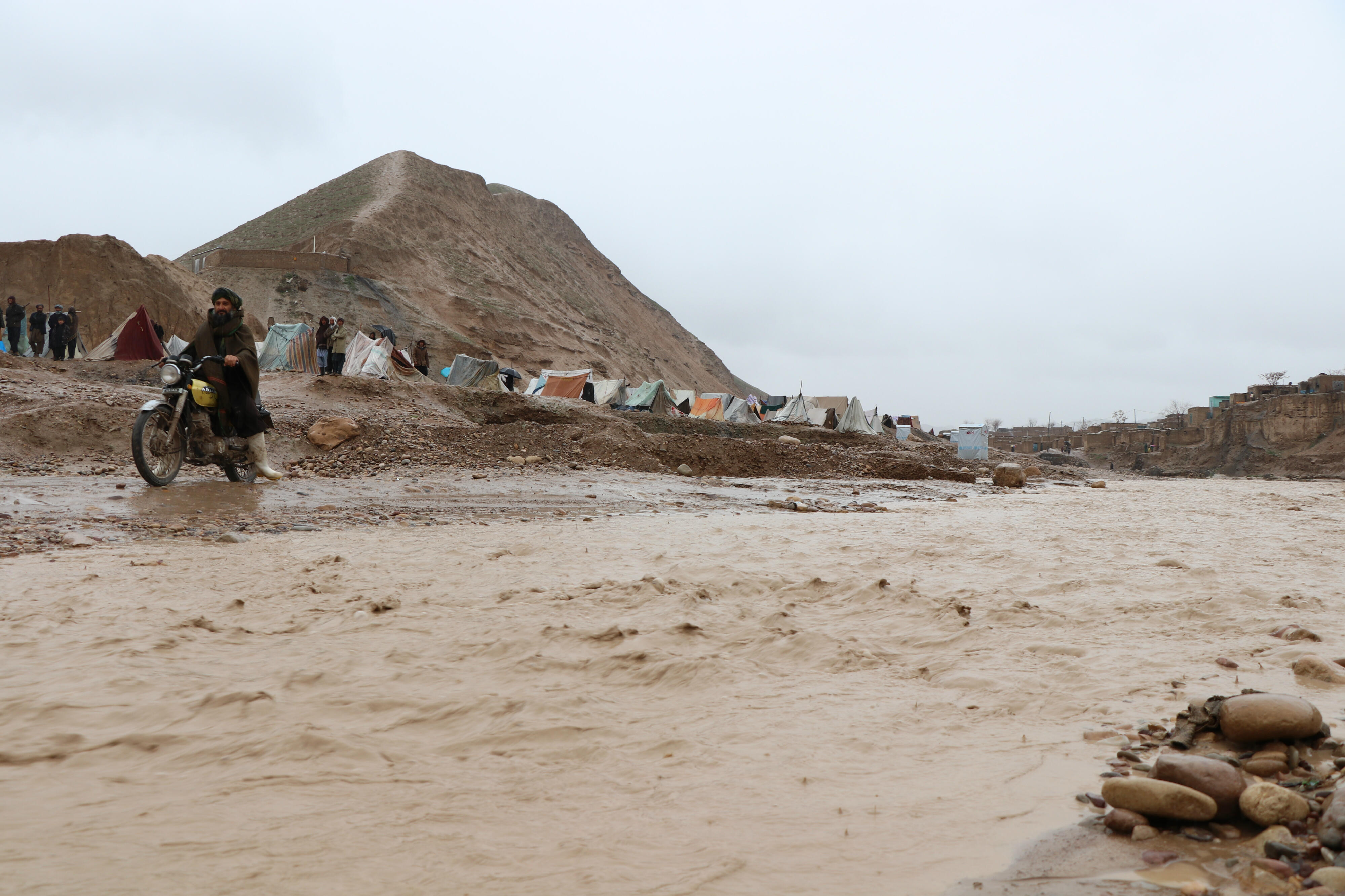 Flood waters surging past a makeshift camp in Afghanistan as floods continue to devastate communities across the country. 