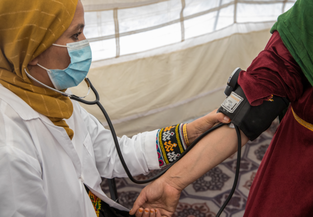 A member of the female mobile health team cares for a female patient.