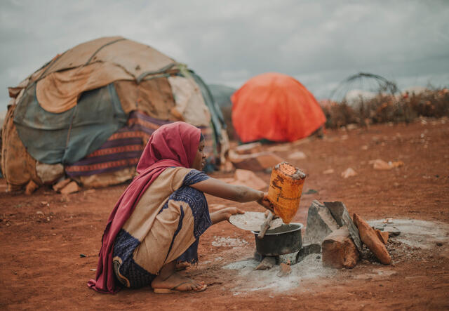 Amina cooks at a makeshift stove outside her tent at Torotorow camp, Somalia