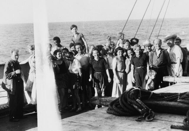 A group of refugees pose for a photo onboard a ship that has departed from the port of Marseille.