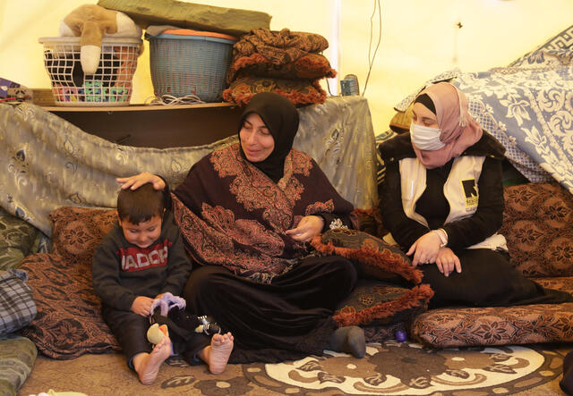Aysha*, ihr Mann, Nabeel*, und ihr Kind, Amjad*, in deren Zelt.