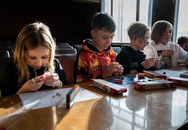 우크라이나의 IRC가 지원하는 '안전한 학습과 치유의 공간'에서 네 명의 아이들이 나란히 학습 활동을 하고 있습니다.