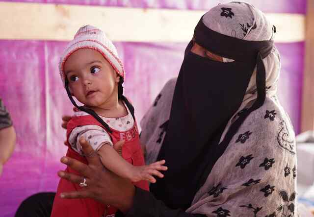 Yemeni mother Asriya holding her baby daughter