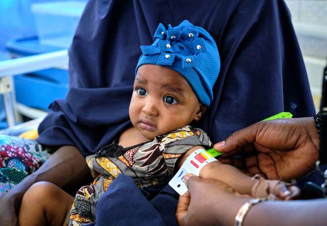 A young child is screened for malnutrition by an IRC staff member in Nigeria.
