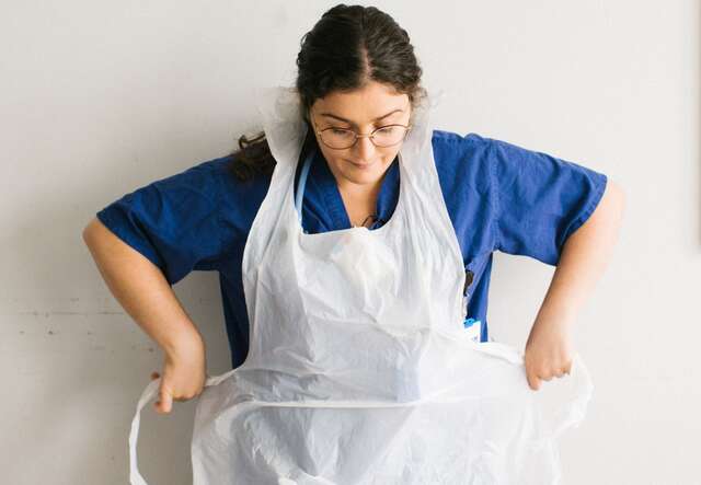 Anxhela Gradeci ties her apron