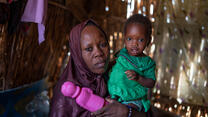 A woman holds her child in her home in Awaridi village, Niger