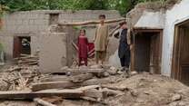 Three children walk through the ruins of their home-devastated by severe flooding.