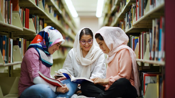 Arifa, Zahra, Hadisa share smiles while sitting in Arizona State University's library.
