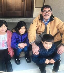 Father and three of his kids from Afghanistan sitting on steps.
