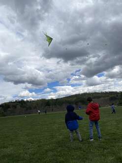 Two children in coats flying a kite