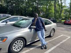 man leaning against his car