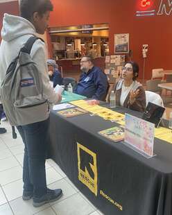 IRC staff Zahra Bajwa speaking with a Montgomery College student. 