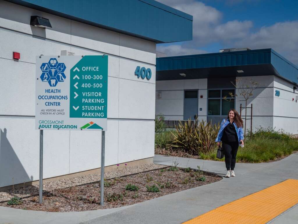 A woman walking in front of a building