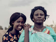 Two women pose for a photo, smiling at the camera.