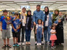 The Hussaini family stand in line facing the camera.