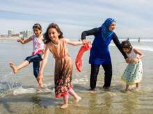 A family plays on the beach.