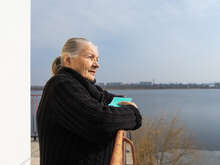 Alla looks out over her balcony.