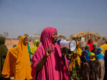 En kvinna i Somalia håller i en megafon och talar till en grupp kvinnor.