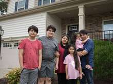 An Afghan family stands outside their home in Richmond.