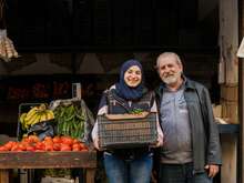 A daughter and father poses for a photo outside of their shop in Lebanon.