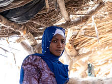A woman poses for a photo in a makeshift shelter in Mali.