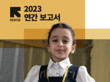 2023 연간 보고서 표지를 당당히 포즈를 취하고 있는 한 어린이 고객이 장식하고 있습니다.