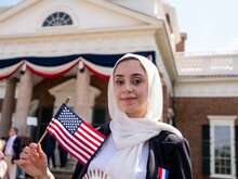 A woman in a hijab holding an American flag