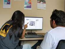 A woman showing something on a computer screen to a man