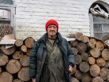 Woman standing in front of fuel logs wearing winter clothes