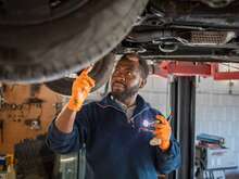 Automechaniker bei der Inspektion eines Fahrzeugs in der Werkstatt