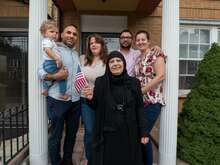 Maha al-Obaidi, 66, stands with her family outside their home in New York.