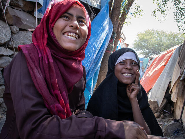 Aisha and Na'aem sitting together and smiling