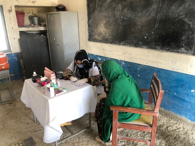 A woman is treated at a makeshift medical facility.