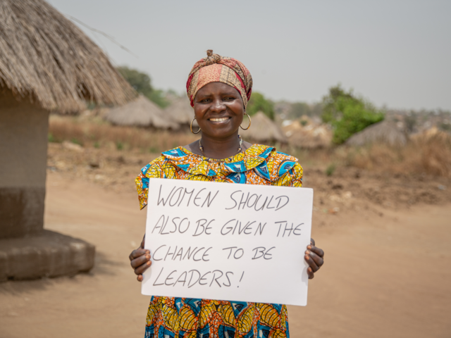 Loyce holds a sign advocating for women's rights in Sierra Leone 