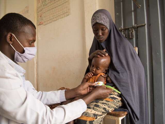 Hassen, a nurse at the stabilization section of the health center, measures the mid-upper arm circumference of two-year-old Mowlid. Mowlid was diagnosed with severe acute malnutrition, but is on the path to recovery after receiving treatment funded by the EU.