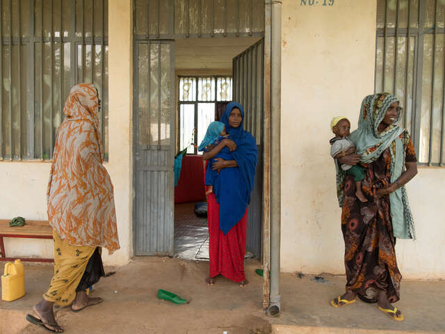 Three mothers stand outside the room they share at the Eelkare health center. They each have a child who is receiving treatment for severe acute malnutrition.
