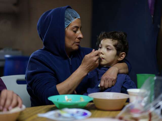 Sara feeds her nine-year-old son who lives with cerebral palsy at a shelter in Ciudad Juárez.