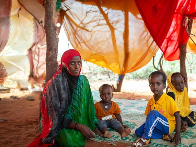 Nasteho and her family sit together on the floor of their home in Somalia.