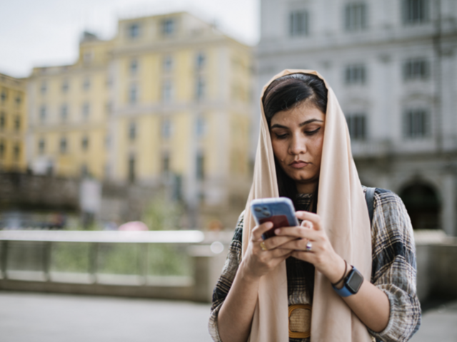 A woman in a hijab looking at her phone