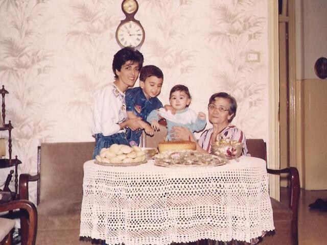 Mariela at a lace-covered table with her mother, grandmother and brother at home in Aleppo